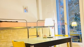 A dining area with a table, chairs, and a lamp. - Europe station rooms (Parma)