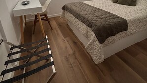 A bedroom with a bed, a desk, and a chair.