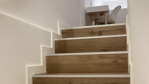 A wooden staircase with white walls and a white handrail.