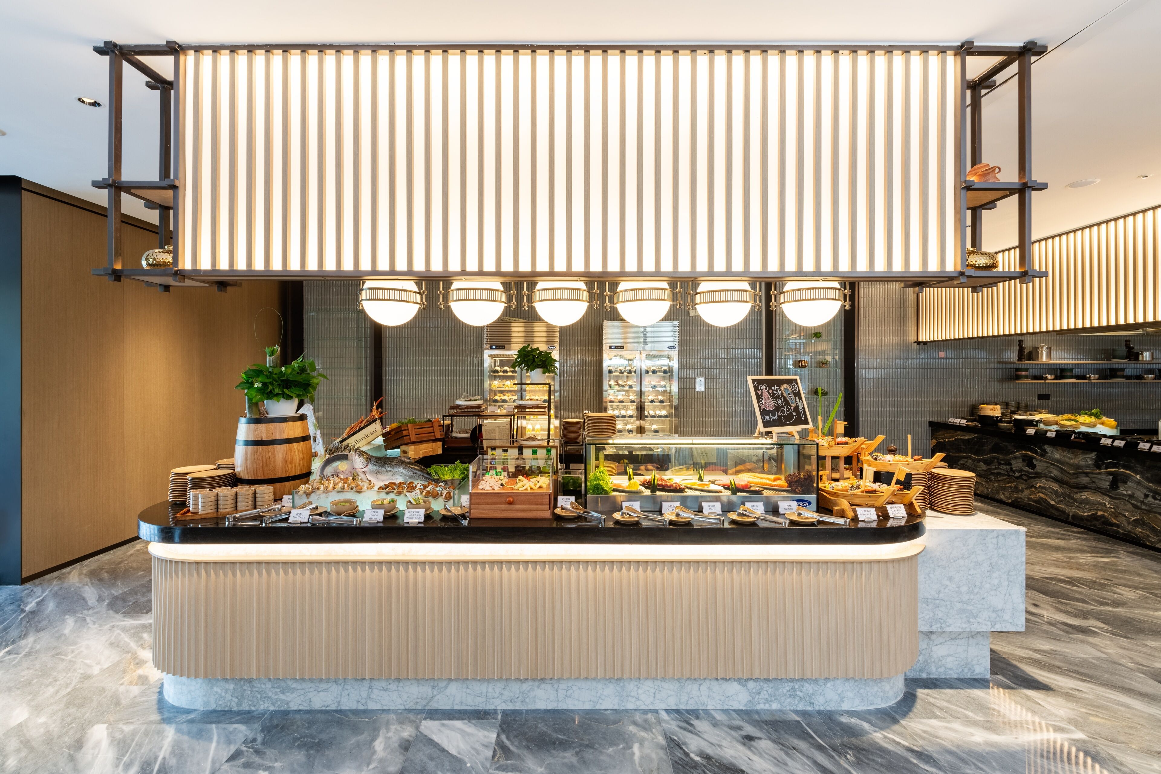 Un mostrador de buffet con varios tipos de comida, una planta y un cartel.