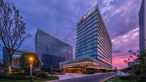 A modern hotel with a glass facade, a prominent sign, and a well-maintained surrounding area. - Nanjing Yangzi River Conference Center Longshan Lake Hotel (Nanjing)