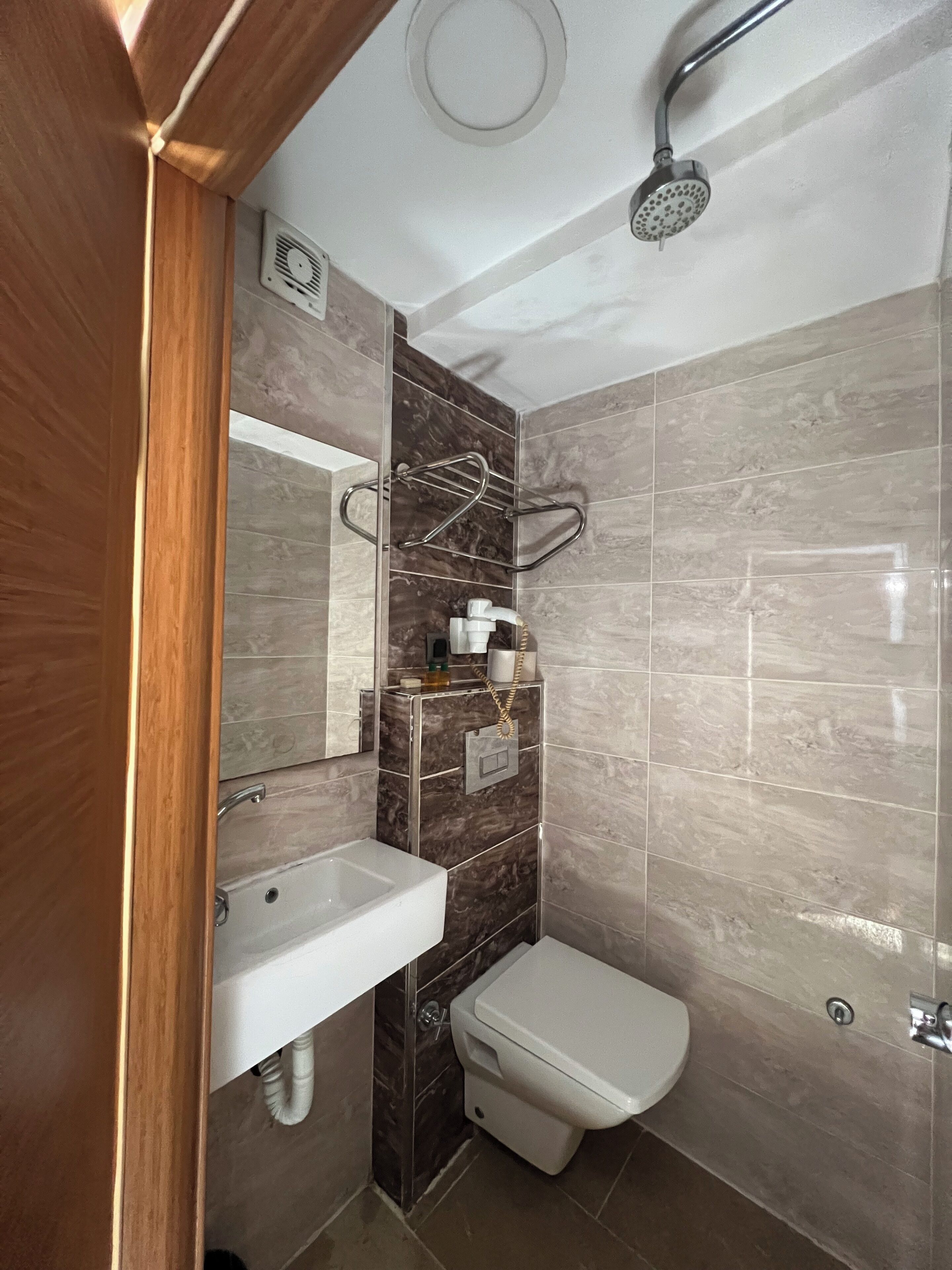 A modern bathroom with a shower, toilet, and sink.