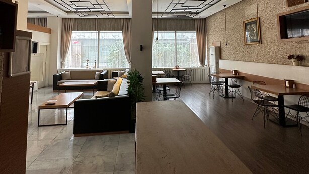A spacious, modern interior with a high ceiling, geometric ceiling design, and a mix of seating areas including sofas and tables. - OKUR OTEL (Istanbul)