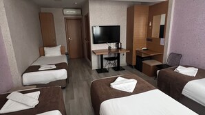 A hotel room with four single beds, a desk with a flat-screen TV, a coffee machine, and a small seating area. - OKUR OTEL (Istanbul)
