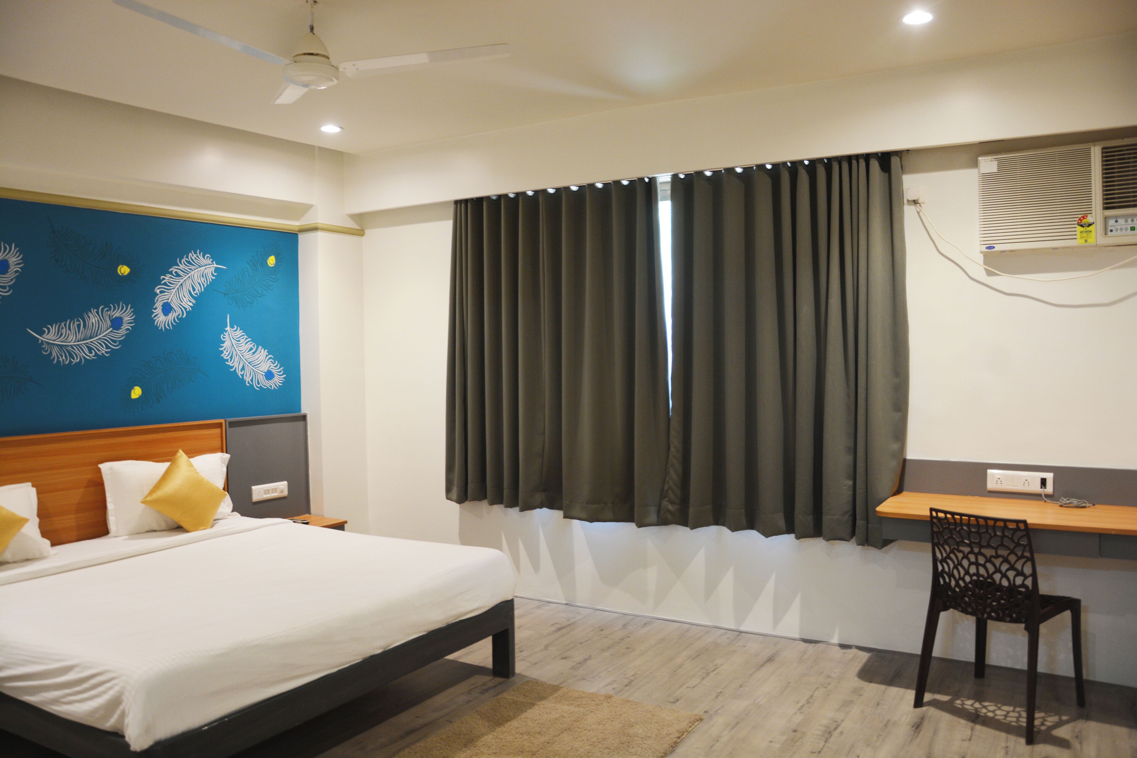 A hotel room with a bed, a desk, and a chair.