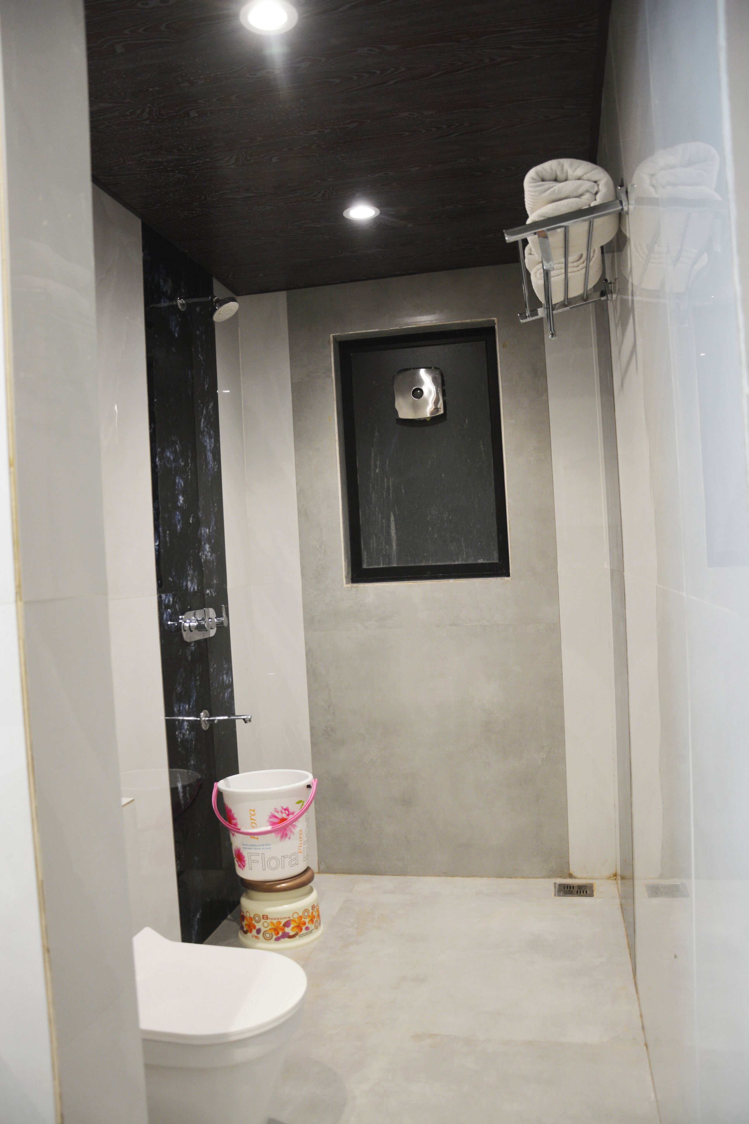 Ein kleines, modernes Badezimmer mit Toilette, Dusche und Handtuchhalter.