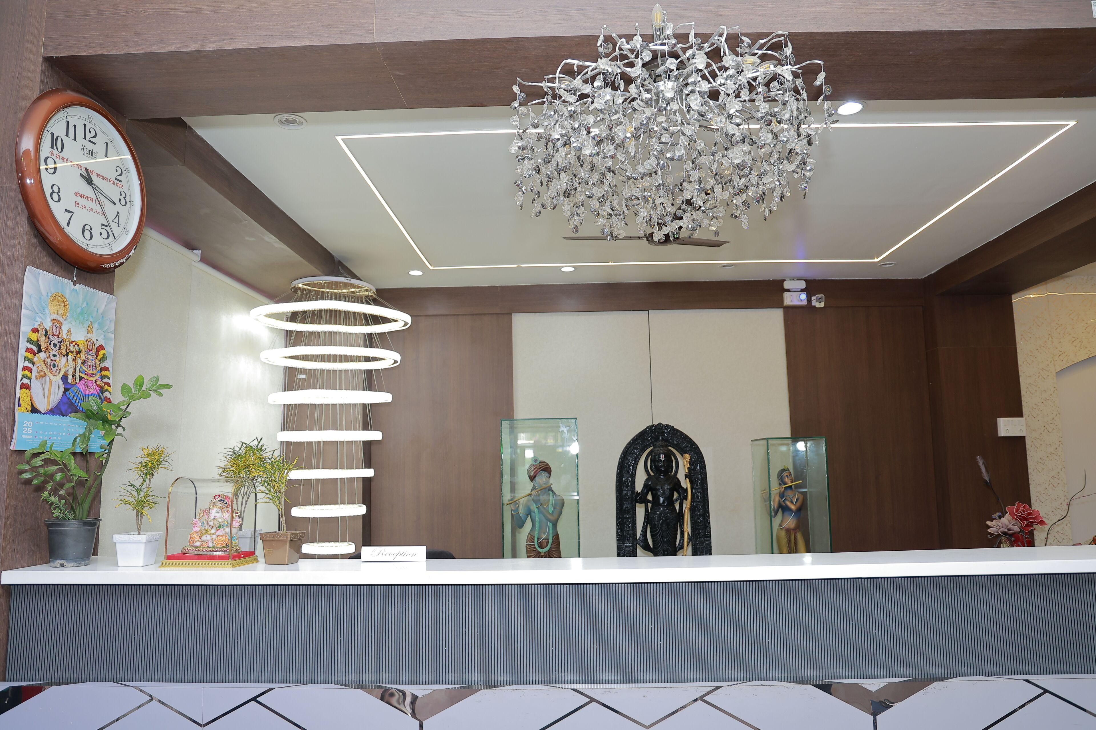 A reception area with a clock, a chandelier, and a reception desk.