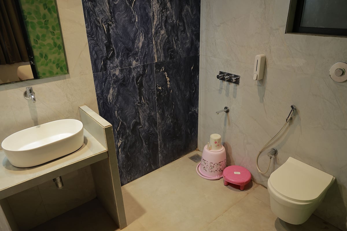 A bathroom with a white sink, a toilet, and a shower area.