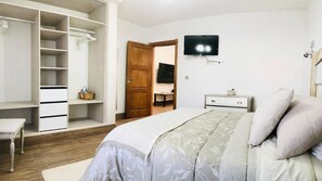A bedroom with a bed, a TV, a wardrobe, and a desk. - Apartment Alegria in the stunning Village of Mozaga, Lanzarote (Mozaga)