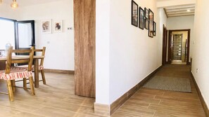 A hallway with a wooden floor, a rug, and framed pictures on the wall. - Apartment Alegria in the stunning Village of Mozaga, Lanzarote (Mozaga)