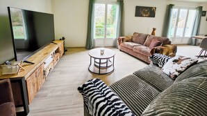 Ein Wohnzimmer mit Fernseher, Sofa und Couchtisch.