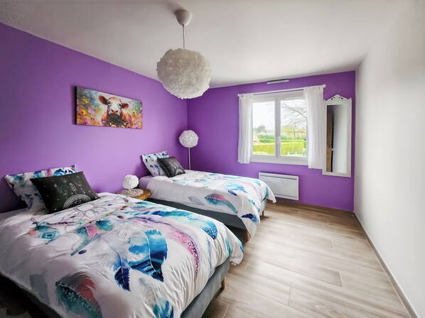 A bedroom with two beds, purple walls, a large window, and a ceiling light fixture. - Villa L'Isachrist, Calm, Comfort, 20' Disneyland (Maisoncelles-en-Brie)