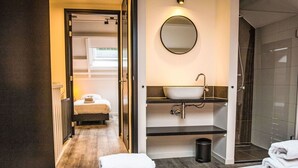 A hotel room with a bed, a bathroom with a sink and mirror, and a shower. - Beautiful private villa for 4 guests with WIFI, TV, terrace and pets allowed (Veere)