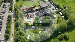 An aerial view of a property with a parking lot, a swimming pool, and a building with a sloped roof. - Beautiful private villa for 4 guests with WIFI, TV, terrace and pets allowed (Veere)