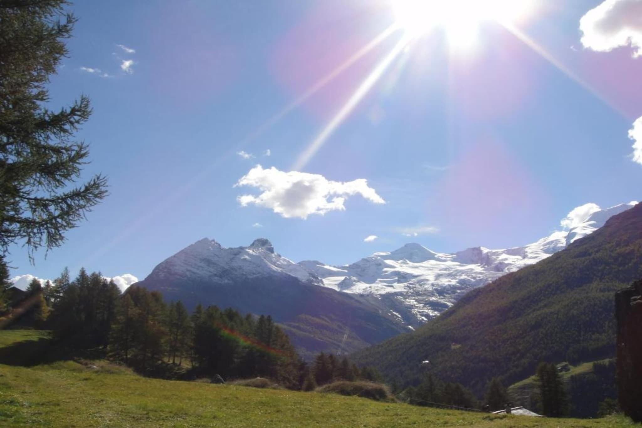 A mountainous landscape with a clear sky and sunlight.
