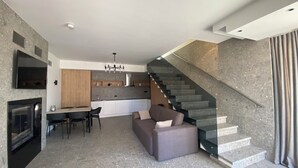 A modern living space with a kitchen, dining area, and a staircase. - Plein Air Residence & Resort (Vatra)