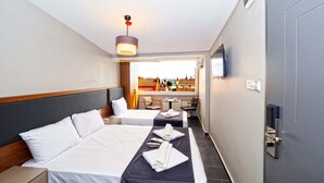 A hotel room with two beds, a small table, a chair, a TV, and a view of the cityscape. - Diamond Hotel Old City (Istanbul)