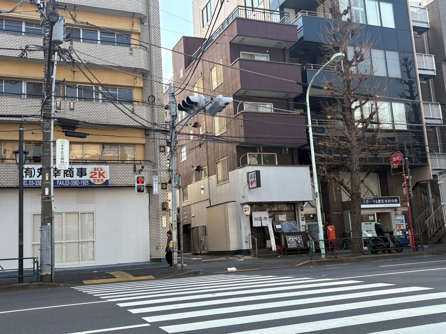 A street view with a crosswalk, buildings, and a traffic light.