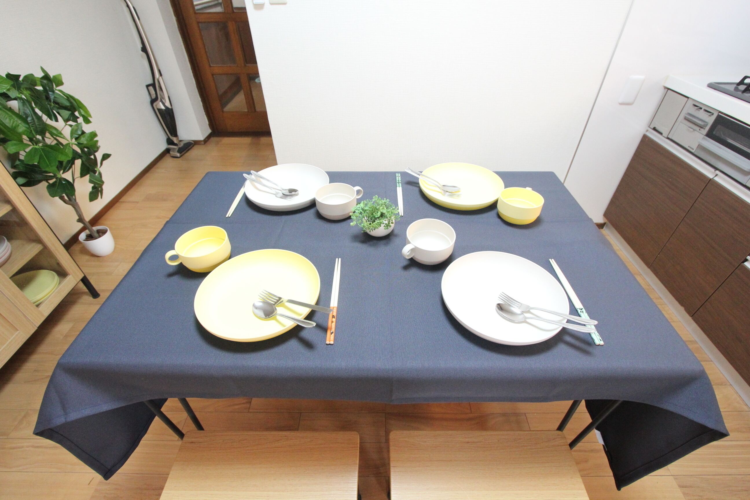 Una mesa de comedor dispuesta con platos, tazones, vasos y cubiertos.
