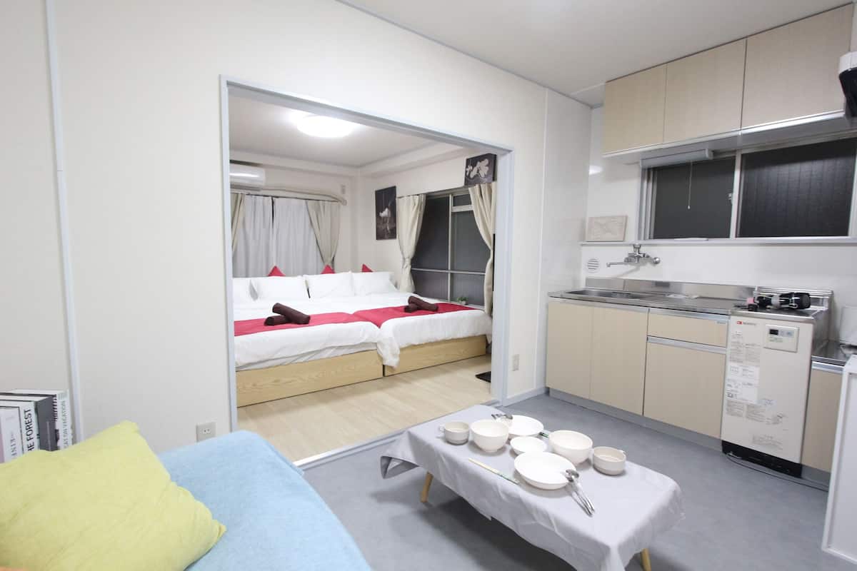 A compact hotel room with a bed, kitchenette, and a small dining area.