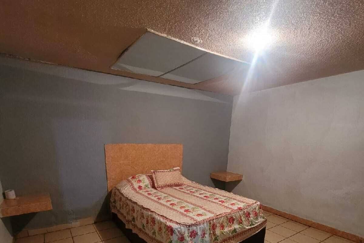 Une chambre à coucher avec un lit, une table de chevet et une petite étagère.