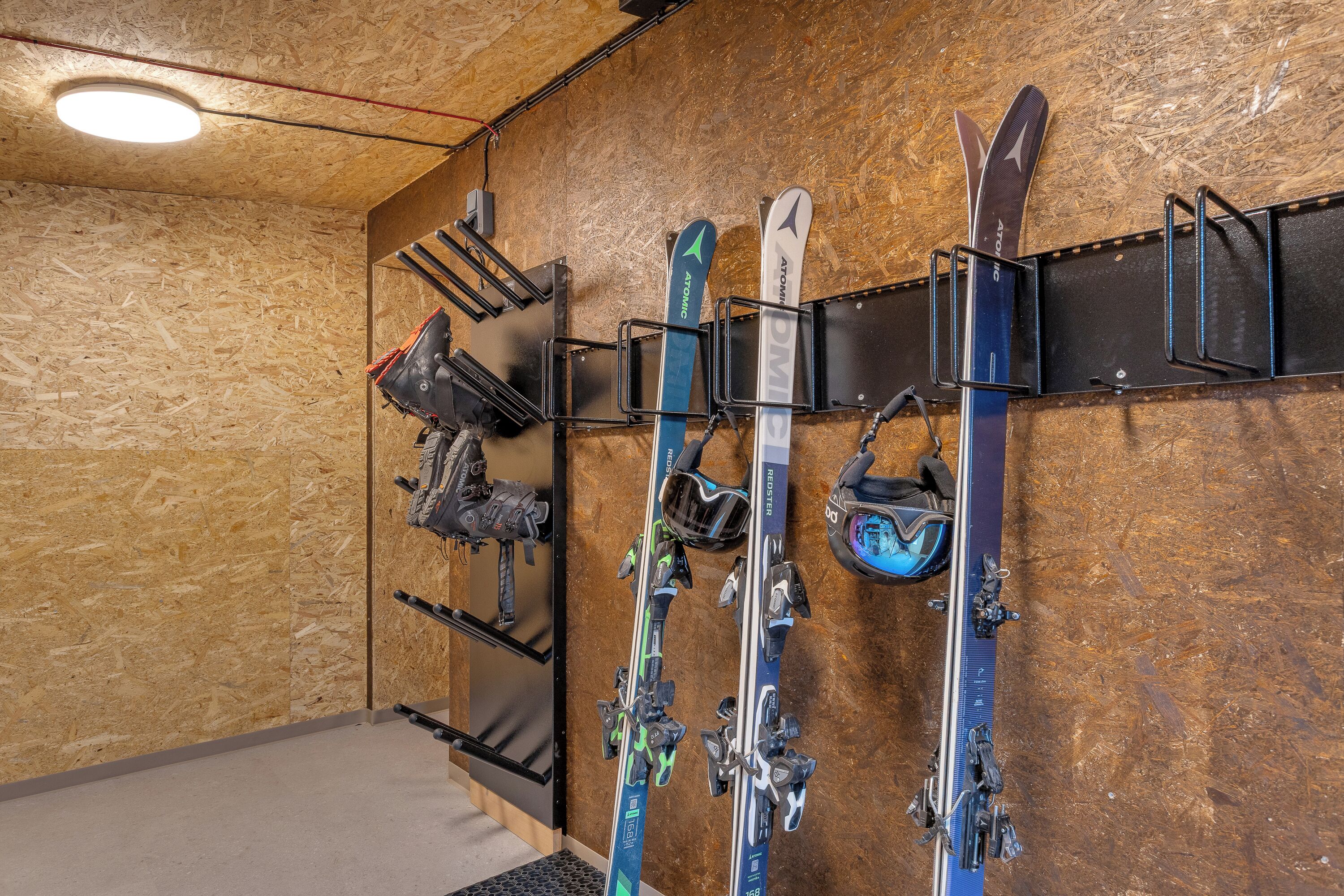A ski storage area with multiple racks holding skis and ski equipment.