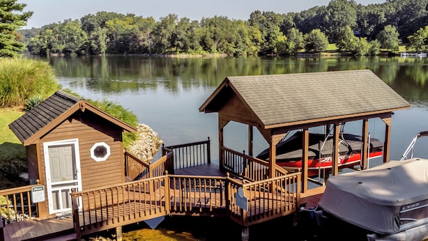 A wooden dock with a covered boat house and a small cabin. - Relax at this serene waterfront retreat featuring a private dock, perfect for lake lovers! (Dublin)