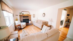 A living room with a fireplace, a sofa, a coffee table, and a lamp. - Relax at this serene waterfront retreat featuring a private dock, perfect for lake lovers! (Dublin)