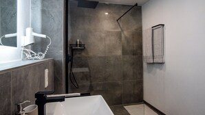 A modern bathroom with a large white sink, a glass-enclosed shower, and a towel rack on the wall. - Ferienwohnungen Moselblick Bekond (Bekond)