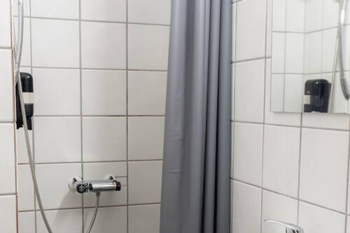 Habitación individual básica | Baño | Ducha, artículos de higiene personal gratuitos y secador de pelo