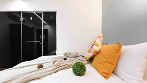 A modern bedroom with a bed, pillows, and decorative items. - At Home Hotel Zhongshan (Taipei)