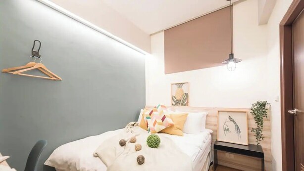 A neatly arranged bedroom with a bed, bedside table, and a hanging light fixture. - At Home Hotel Zhongshan (Taipei)