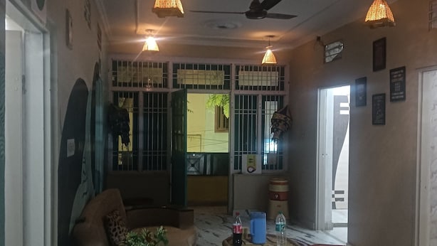A living room with a sofa, a round wicker table, and a ceiling fan. - Jungle by sturmfrei Jaipur (Jaipur)
