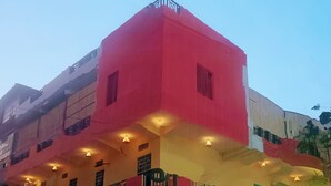 A multi-story building with a red facade, balconies, and a green gate. - Jungle by sturmfrei Jaipur (Jaipur)