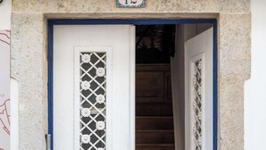 A white door with a blue frame, a number '12' above it, and a decorative window. - Central Studio Suite - Ericeira (Ericeira)