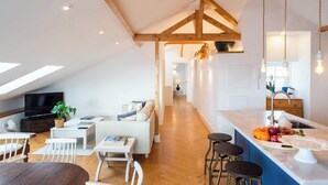 A modern loft apartment with a dining area, living room, and kitchen. - Ocean View Penthouse with Rooftop Terrace! (Ericeira)