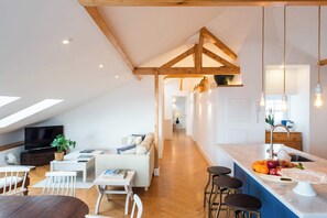 Un appartement moderne de style « loft » comprenant un coin repas, un salon et une cuisine.