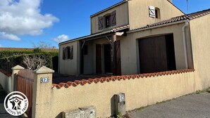 A two-story building with a beige facade, a tiled roof, and a gated entrance. - Charming cottage for 6 in Jard-sur-Mer, close to beach and Vélodyssée (Jard-sur-Mer)