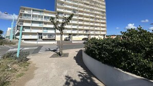 A multi-story building with balconies, a pedestrian crossing, and a small tree in the foreground. - 3-room flat with balcony, sleeps 6 in Saint-Jean-de-Monts (Saint-Jean-de-Monts)