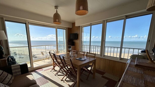 A spacious room with a large dining table, chairs, and a view of the beach. - 3-room flat with balcony, sleeps 6 in Saint-Jean-de-Monts (Saint-Jean-de-Monts)