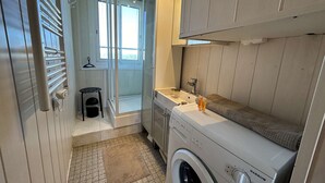 A compact laundry room with a front-loading washer, a small sink, and a towel rack. - 3-room flat with balcony, sleeps 6 in Saint-Jean-de-Monts (Saint-Jean-de-Monts)