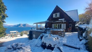 A wooden house with a balcony overlooking a lake, surrounded by snow. - ENCHANTING LOFT "Shambalahome.it" (STRESA)
