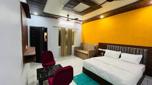 A bedroom with a bed, a desk, and a chair. - Glorious Resort Rishikesh (Rishikesh)