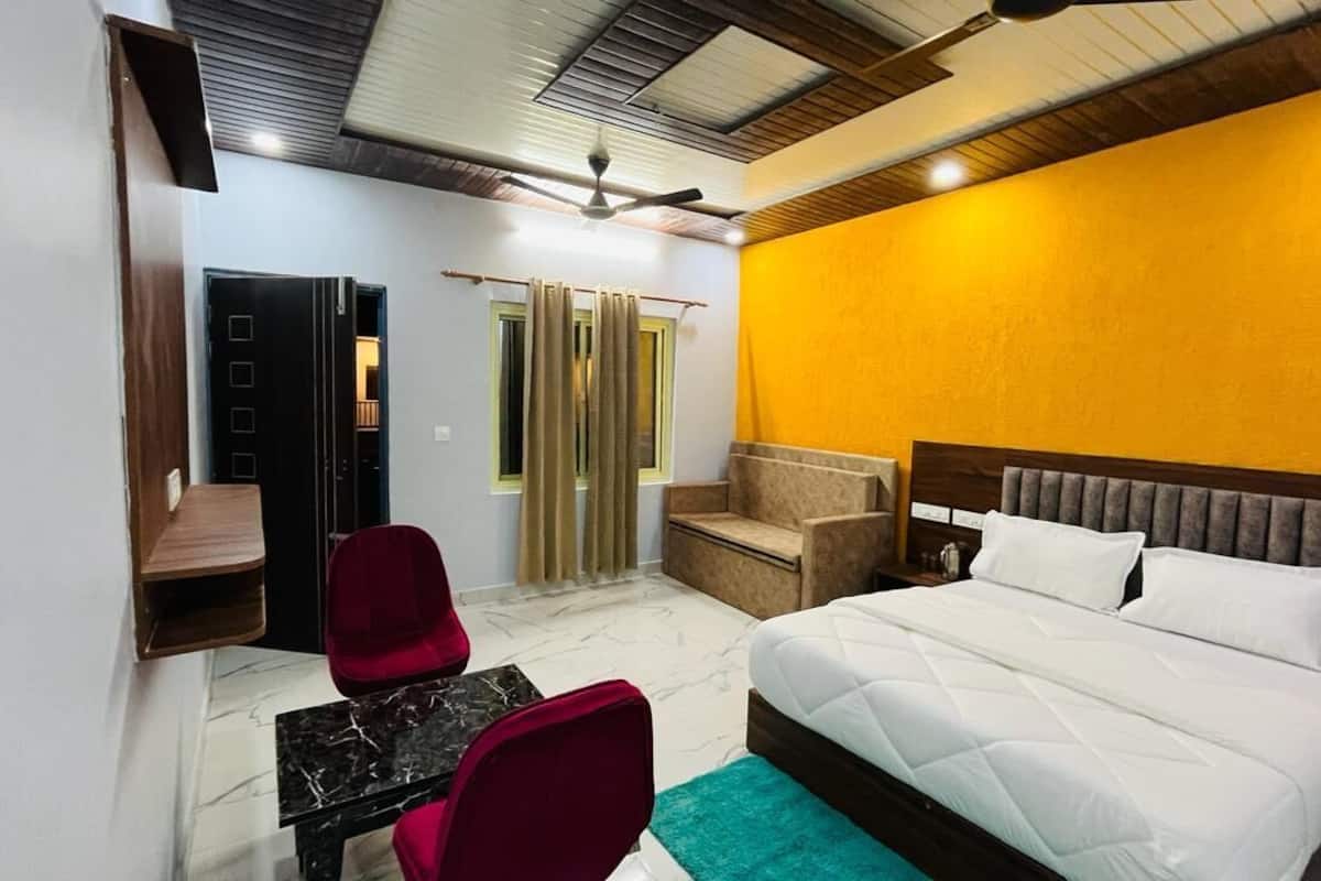 A bedroom with a bed, a desk, and a chair.