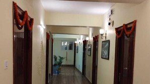 Un couloir doté d’un plancher en bois, de murs de couleur crème et de portes en bois foncé.