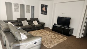 A living room with a sectional sofa, a flat-screen TV, and a shaggy rug. - Tranquil in Alfredton (Alfredton)