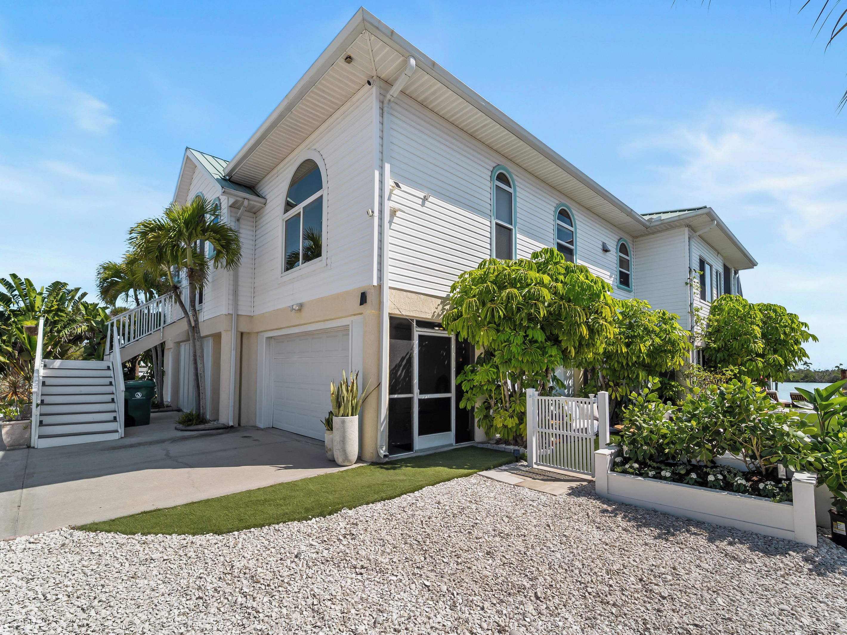 A two-story house with a garage, a front porch, and a well-maintained lawn.