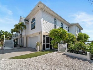 A two-story house with a garage, a front porch, and a well-maintained lawn.