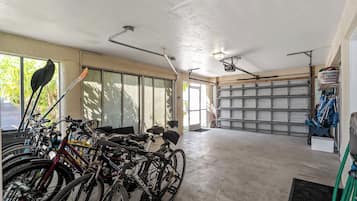 Eine Garage mit darin abgestellten Fahrrädern, einem Betonboden und einer Garagentür.