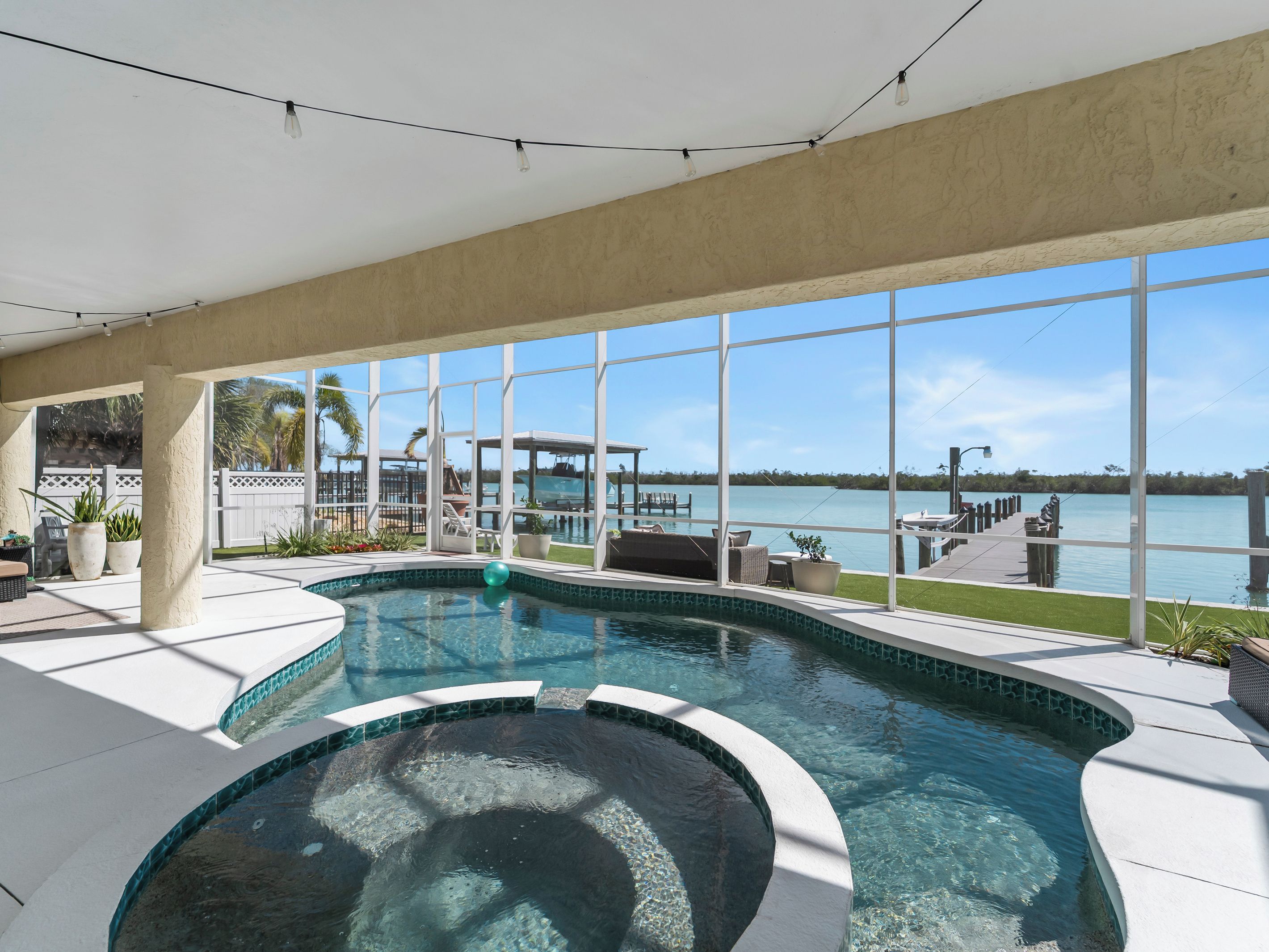 Una piscina interior con vista a un lago y un muelle.